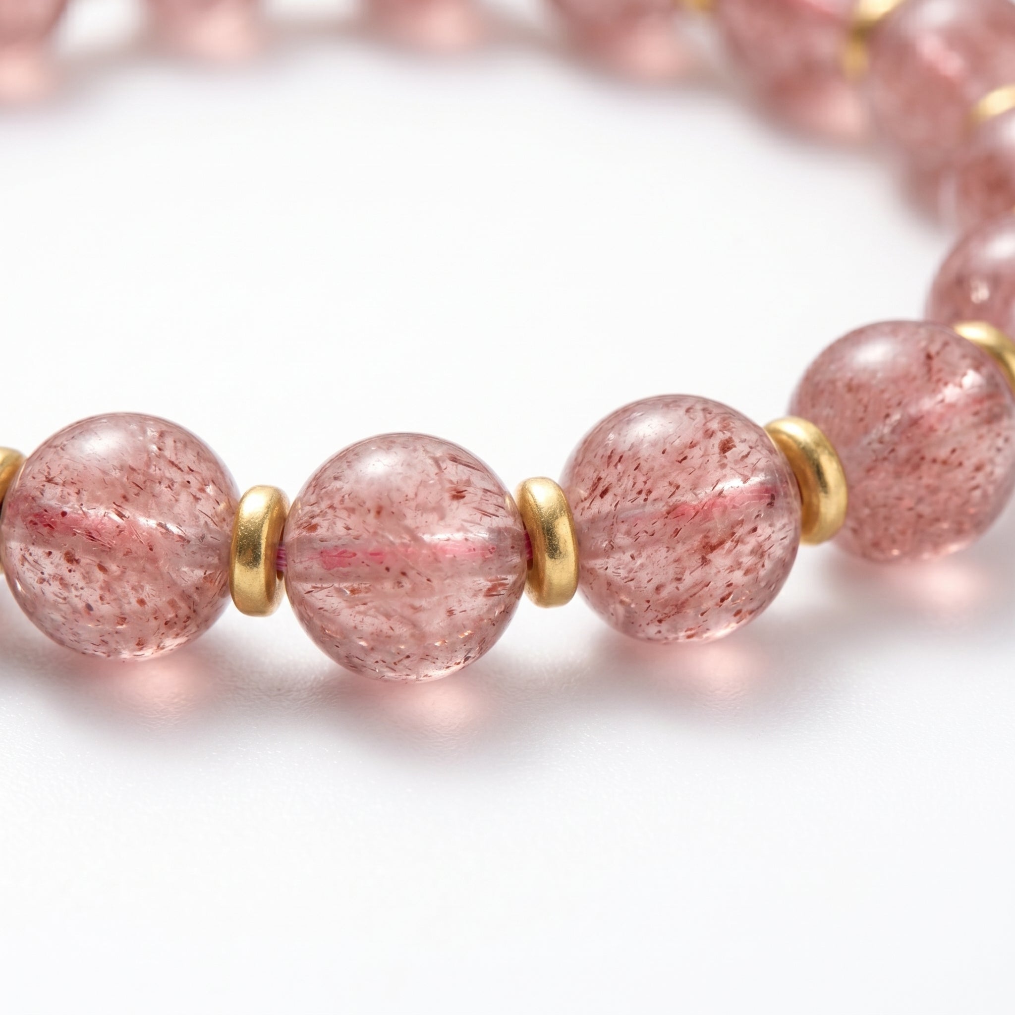 Strawberry quartz rounds close-up · white base with red iron-needle inclusions